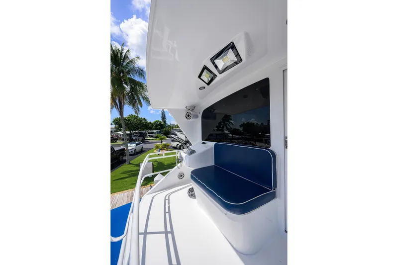 Slide: The Image of 2001 Viking 65 Enclosed Bridge yacht with blue seating and palm trees in the background. - 49