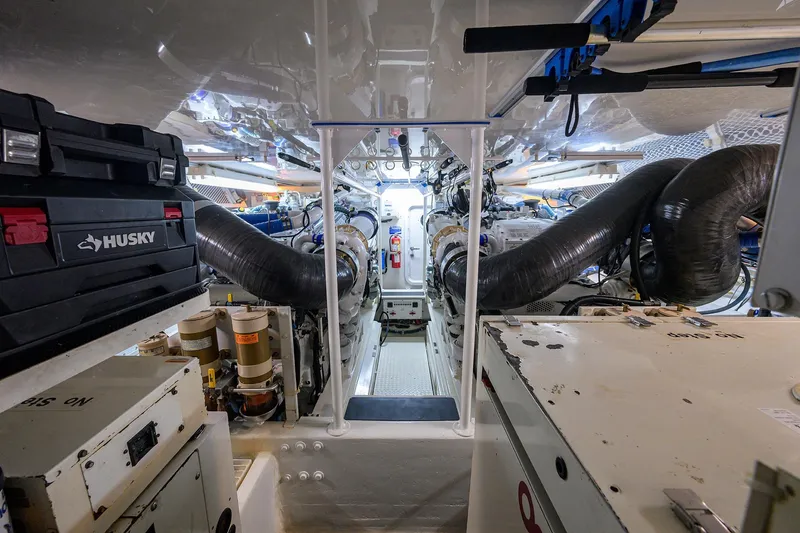Slide: The Image of Engine room of a 2001 Viking 65 Enclosed Bridge yacht, featuring mechanical components and tools. - 53