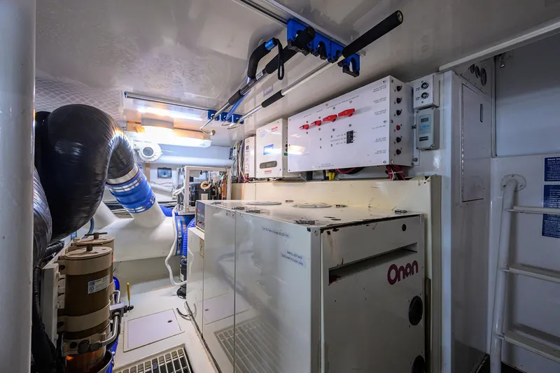 Slide: The Image of Engine room of 2001 Viking 65 Enclosed Bridge yacht with Onan generator and control panels. - 55