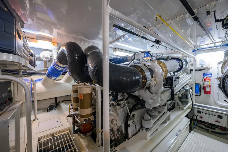 Slide: The Image of Engine room of 2001 Viking 65 Enclosed Bridge yacht, featuring complex machinery and equipment. - 56