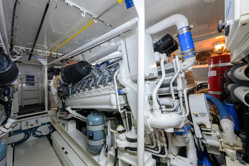 Slide: The Image of Engine room of 2001 Viking 65 Enclosed Bridge yacht, showcasing complex machinery and piping. - 59
