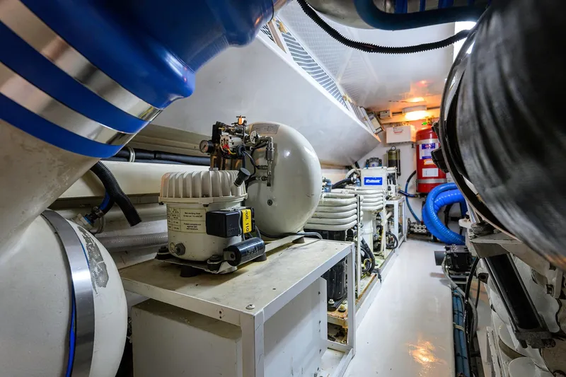 Slide: The Image of Engine room of 2001 Viking 65 Enclosed Bridge yacht, featuring mechanical equipment and piping. - 61