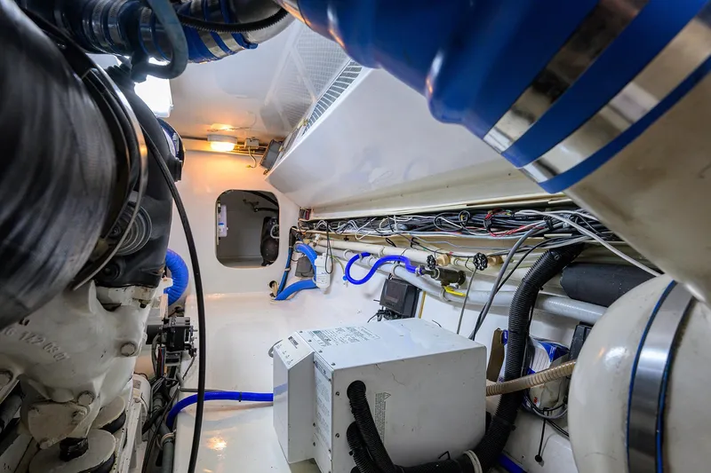 Slide: The Image of Engine room of 2001 Viking 65 Enclosed Bridge yacht, showcasing mechanical components and wiring. - 62