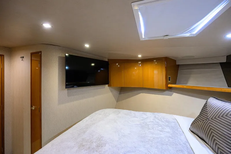 Slide: The Image of Interior of 2001 Viking 65 Enclosed Bridge yacht bedroom with TV and skylight. - 65
