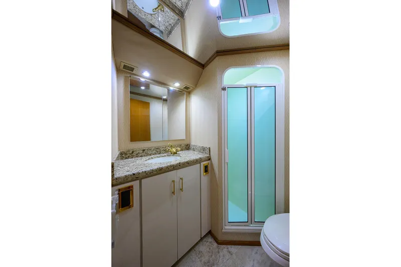 Slide: The Image of Luxurious bathroom in 2001 Viking 65 Enclosed Bridge yacht with granite countertop and shower. - 68