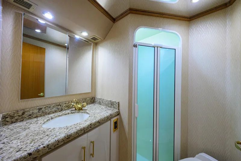 Slide: The Image of Luxurious bathroom in 2001 Viking 65 Enclosed Bridge yacht with granite countertop and glass shower. - 69