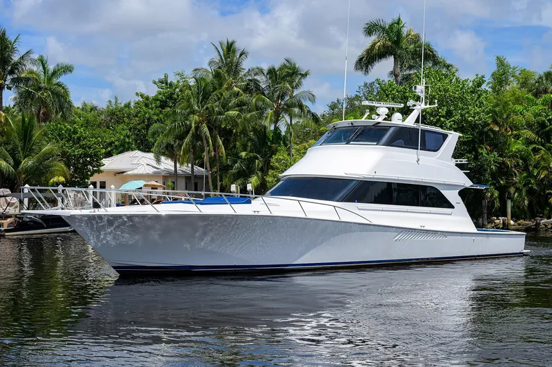 Slide: The Image of 2001 Viking 65 Enclosed Bridge yacht on a serene waterway with lush greenery. - 7