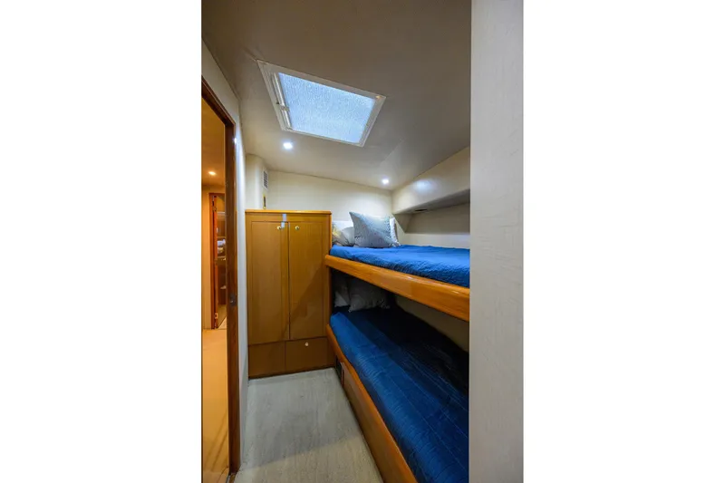 Slide: The Image of 2001 Viking 65 Enclosed Bridge cabin with bunk beds and wooden cabinetry. - 74