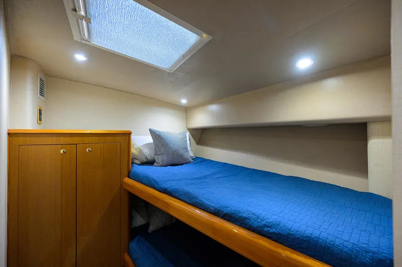 Slide: The Image of 2001 Viking 65 Enclosed Bridge cabin with bunk beds and blue bedding. - 75