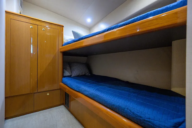 Slide: The Image of Bunk beds in 2001 Viking 65 Enclosed Bridge yacht cabin with wooden cabinetry. - 76
