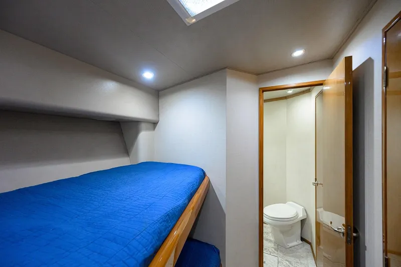 Slide: The Image of 2001 Viking 65 Enclosed Bridge cabin with blue bedding and private bathroom. - 77