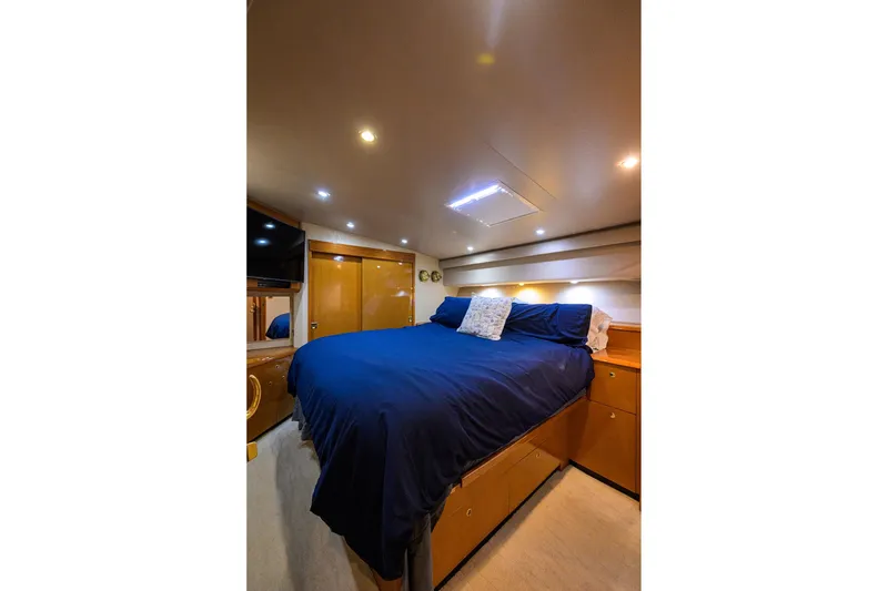 Slide: The Image of Luxurious bedroom interior of 2001 Viking 65 Enclosed Bridge yacht with blue bedding. - 82
