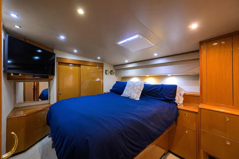 Slide: The Image of Luxurious bedroom interior of 2001 Viking 65 Enclosed Bridge yacht with wood cabinetry. - 83