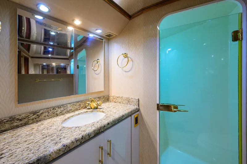 Slide: The Image of Luxurious bathroom in 2001 Viking 65 Enclosed Bridge yacht with granite countertop and glass shower. - 88