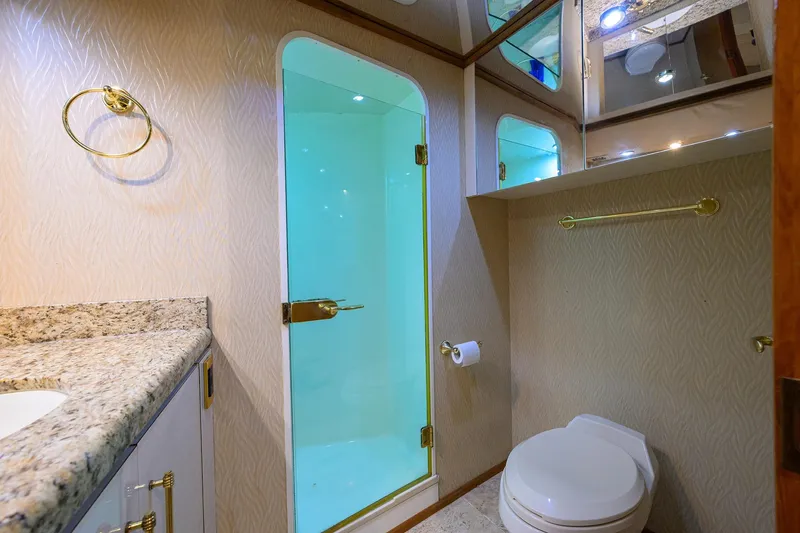 Slide: The Image of Luxurious bathroom in 2001 Viking 65 Enclosed Bridge yacht with shower and granite countertop. - 90