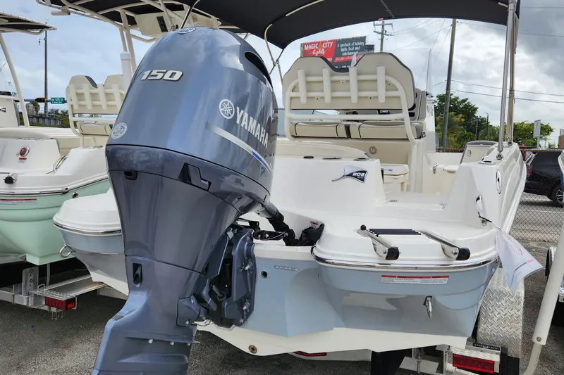 Slide: The Image of 2023 Stingray 206cc boat with Yamaha 150 outboard motor, displayed outdoors. - 2