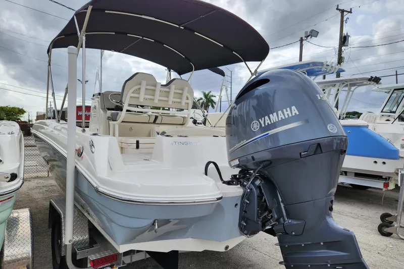 Slide: The Image of 2023 Stingray 206cc boat with Yamaha outboard motor, parked on a trailer. - 3