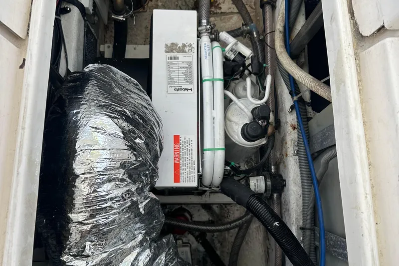 Slide: The Image of Engine compartment of a 1998 Rampage 28 Express boat, featuring mechanical components and wiring. - 10