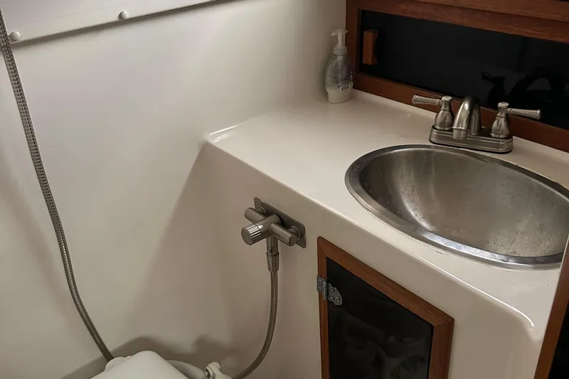 Slide: The Image of 1998 Rampage 28 Express boat bathroom with sink, faucet, and showerhead. - 11