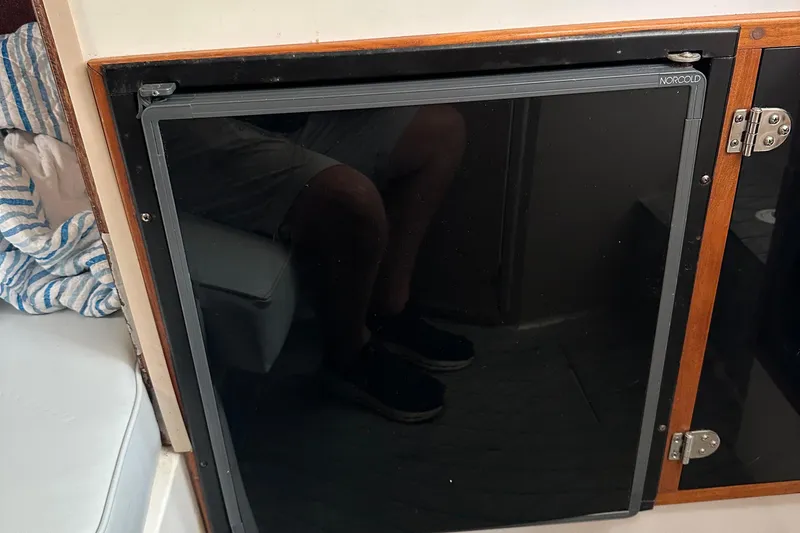 Slide: The Image of 1998 Rampage 28 Express boat interior with Norcold refrigerator and wooden cabinetry. - 15