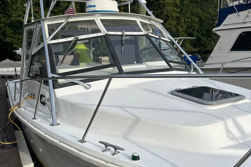 Slide: The Image of 1998 Rampage 28 Express boat docked, featuring sleek design and sturdy railings. - 2