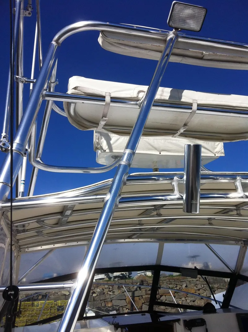 Slide: The Image of 1998 Rampage 28 Express boat with stainless steel railings and clear blue sky background. - 3