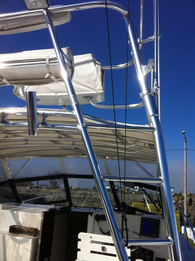 Slide: The Image of 1998 Rampage 28 Express boat with metal framework and clear blue sky background. - 6