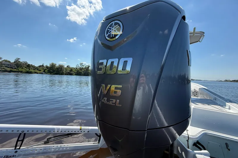 Slide: The Image of 2024 Contender 26 Bay boat with Yamaha 300 V6 4.2L engine on a sunny lake. - 10