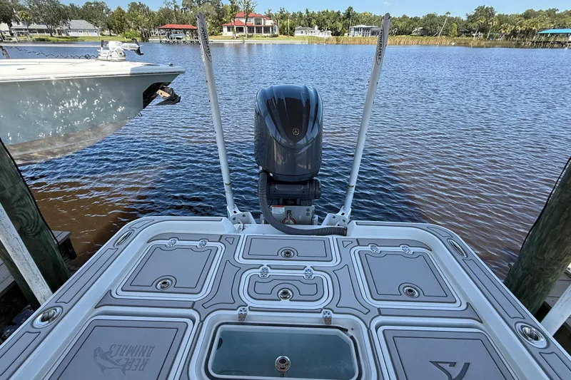 Slide: The Image of 2024 Contender 26 Bay boat docked by a serene waterfront, showcasing its sleek design. - 12