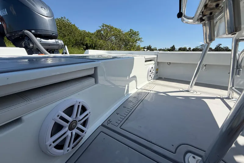 Slide: The Image of 2024 Contender 26 Bay boat interior with Yamaha engine, speakers, and seating. - 13