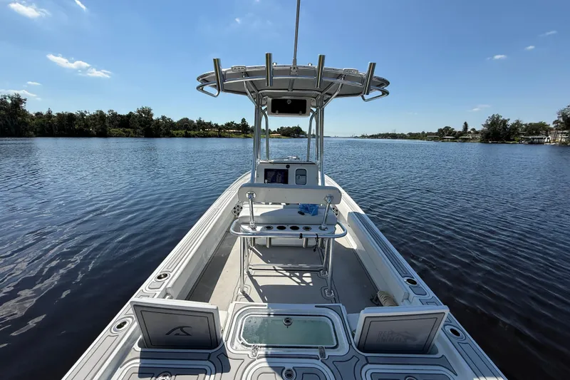 Slide: The Image of 2024 Contender 26 Bay boat on a calm lake under a clear blue sky. - 14