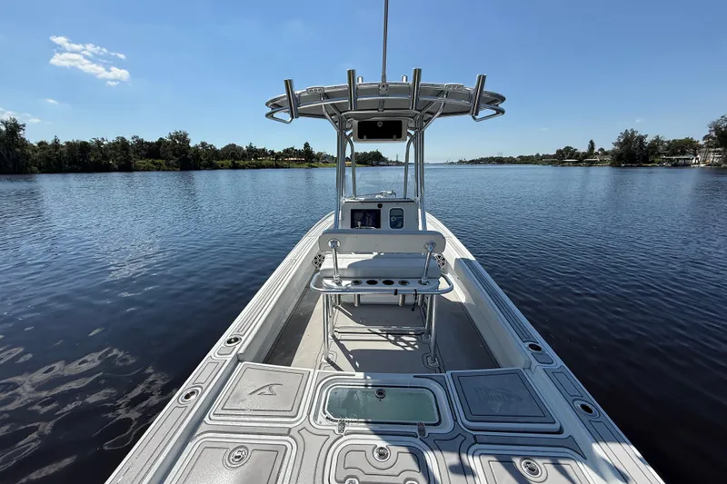 Slide: The Image of 2024 Contender 26 Bay boat on calm water, showcasing sleek design and spacious deck. - 15