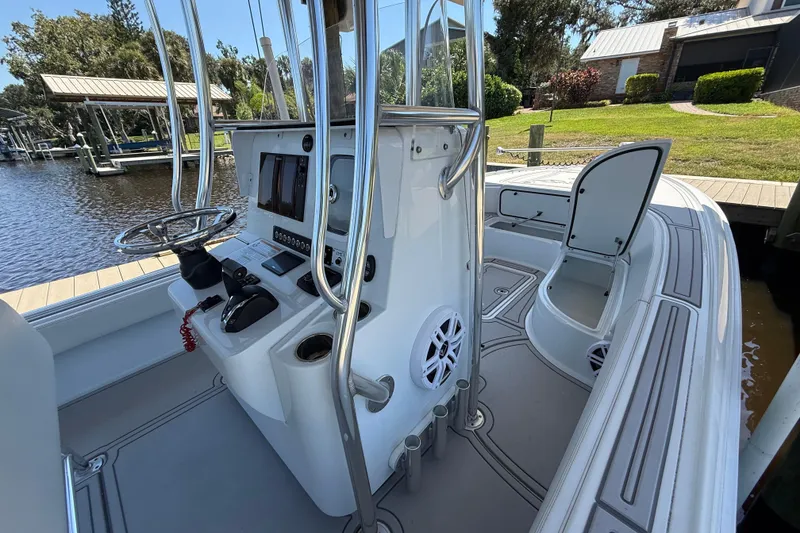 Slide: The Image of 2024 Contender 26 Bay boat interior with steering console and open storage compartment. - 17