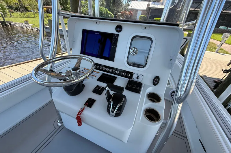 Slide: The Image of 2024 Contender 26 Bay boat console with steering wheel, controls, and navigation display. - 18