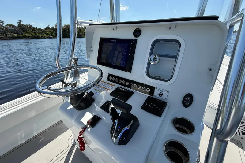 Slide: The Image of 2024 Contender 26 Bay boat helm with steering wheel and navigation controls. - 20