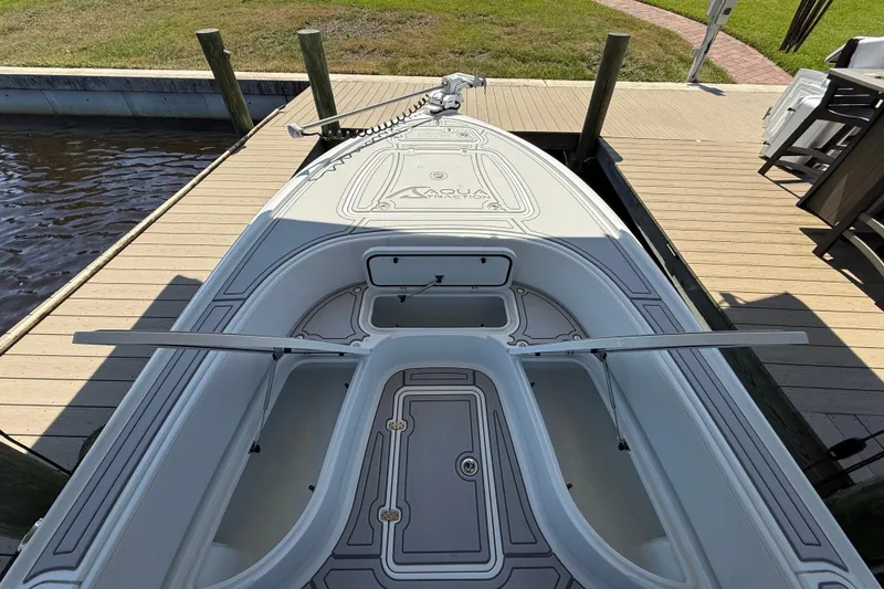 Slide: The Image of 2024 Contender 26 Bay boat docked, showcasing spacious deck and storage compartments. - 26