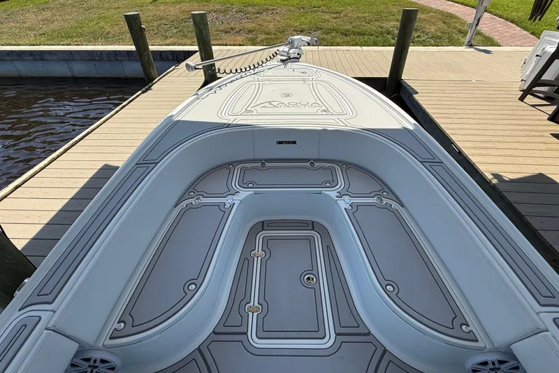 Slide: The Image of 2024 Contender 26 Bay boat docked, showcasing sleek deck design and spacious seating. - 29