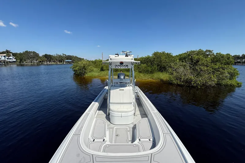 Slide: The Image of 2024 Contender 26 Bay boat on calm water near lush green shoreline. - 31