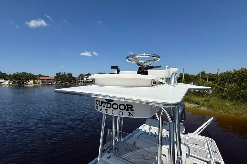 Slide: The Image of 2024 Contender 26 Bay boat with elevated helm, on a calm waterway under clear blue skies. - 33