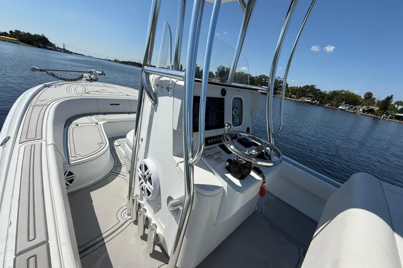 Slide: The Image of 2024 Contender 26 Bay boat interior with steering console on calm water. - 36