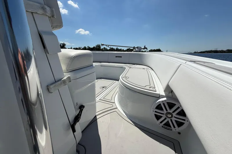 Slide: The Image of 2024 Contender 26 Bay boat interior with white seating and speaker, under clear blue sky. - 37