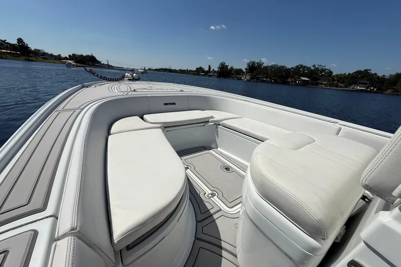 Slide: The Image of 2024 Contender 26 Bay boat interior with white seating, on a calm lake. - 40