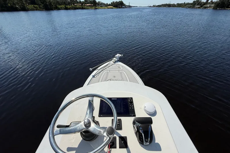Slide: The Image of 2024 Contender 26 Bay boat steering view on a calm river. - 43