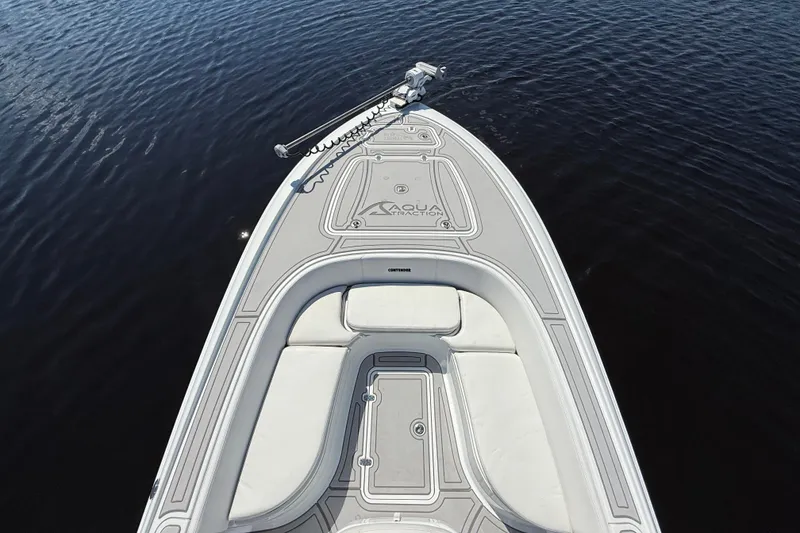 Slide: The Image of 2024 Contender 26 Bay boat deck on calm water, showcasing sleek design and seating. - 44
