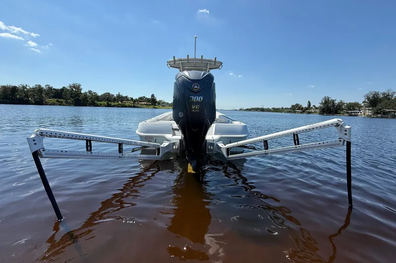 Slide: The Image of 2024 Contender 26 Bay boat with Yamaha 300 V6 engine on calm water. - 6