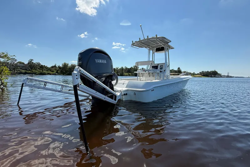Slide: The Image of 2024 Contender 26 Bay boat with Yamaha engine on calm water under clear sky. - 7