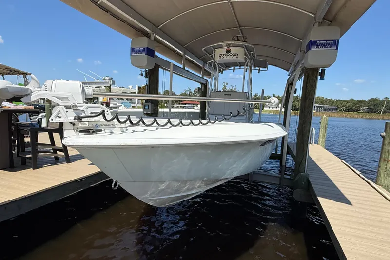 Slide: The Image of 2024 Contender 26 Bay boat docked under a canopy on a sunny day. - 8
