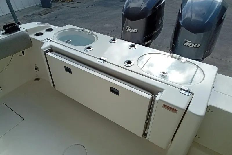 Slide: The Image of 2014 Cobia 296 Center Console boat with dual Yamaha 300 engines and fishing amenities. - 13