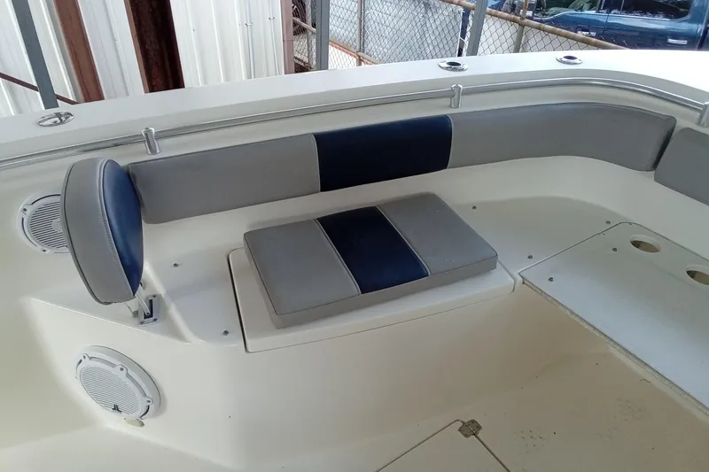 Slide: The Image of 2014 Cobia 296 Center Console boat seating area with cushioned bench and speakers. - 16