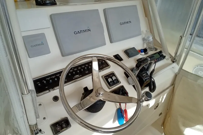 Slide: The Image of 2014 Cobia 296 Center Console helm with Garmin navigation displays and steering wheel. - 19